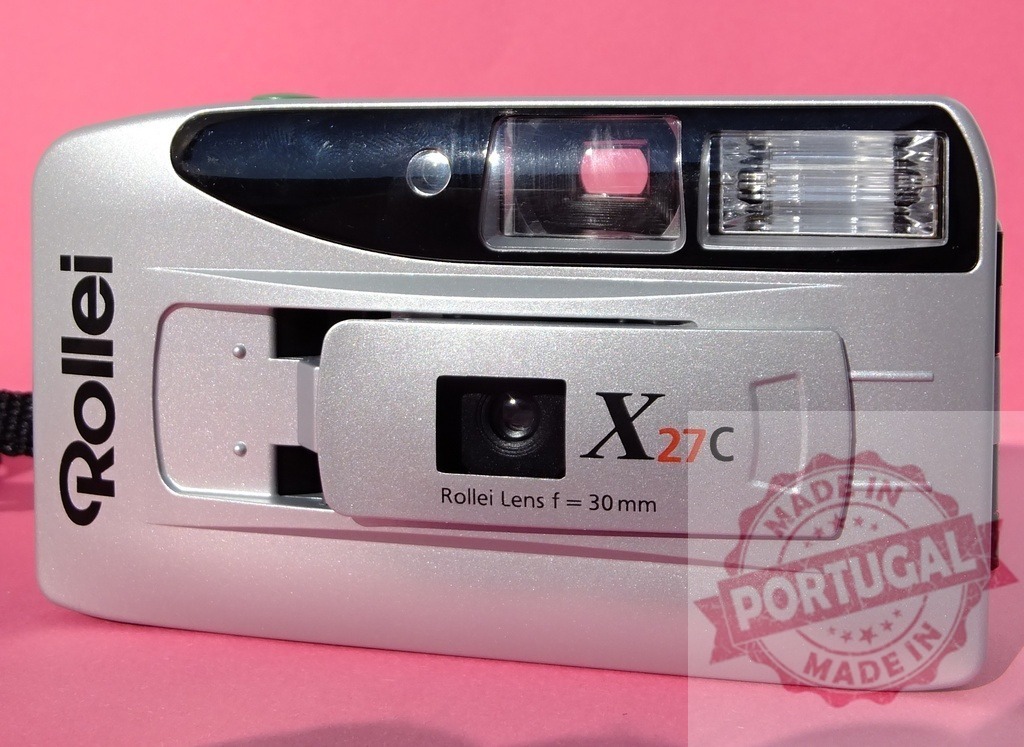 Rollei X27C vintage point and shoot film camera displaying classic design | Rollei X27C compact silver film camera on pink backdrop for analog photography - Realized with Pictrs.com