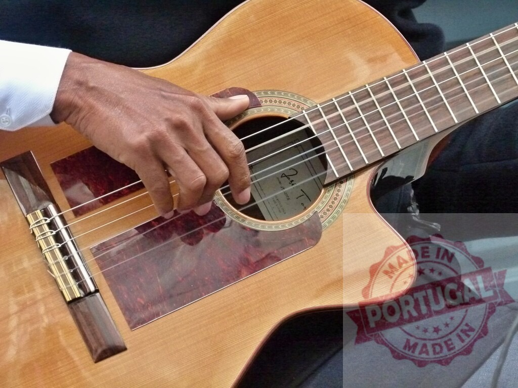 Musician playing acoustic guitar during a performance | Close-up of a musician's hand plucking the strings of an acoustic guitar during a live performance - Realized with Pictrs.com