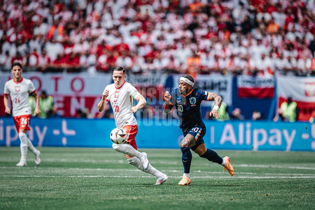 Fußball | Herren | UEFA-Fußball-Europameisterschaft 2024 | Gruppe D | Polen vs. Niederlande | 16.06.2024 | v.l. Piotr Zielinski (#10, Polen) und Memphis Depay (#10, Niederlande) laufen um den Ball