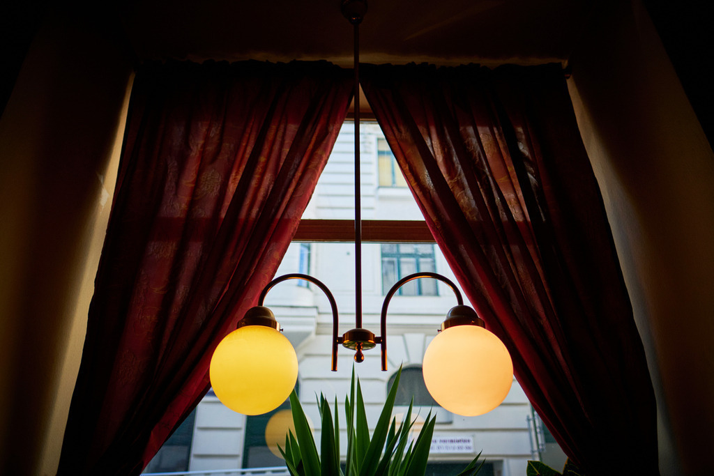 Cafe Volkstheater | WIen, Austria - February 20, 2020: Cafe Volkstheater; Blick durch das Fenster mit roten Vorhängen nach draussen. - Realisiert mit Pictrs.com