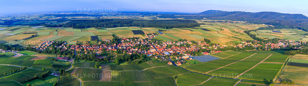 Aerial view: Village panorama from the northeast in Steinseltz in the state Bas-Rhin, France. – Photo: IMG_100666-Pano.jpg taken on 06/02/2017 by Werner Riehm/FLY-FOTO.com – Resolution of the original: 9964 x 2798 px