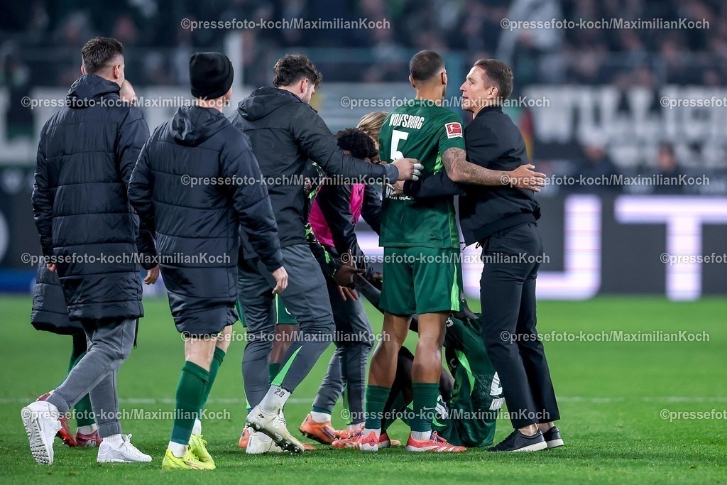 BMG13122502207 | 13.12.2025, Fußball, Borussia Mönchengladbach - VfL Wolfsburg, 1. Fußball Bundesliga, 14.Spieltag, Borussia-Park, Saison 2025 2026: Interimstrainer Daniel Bauer (VfL Wolfsburg #hc) stürmt nach dem Sieg glücklich zu Vini Souza&nbsp;(VfL Wolfsburg #05) und Sael Kumbedi&nbsp;(VfL Wolfsburg #26)  auf das Spielfeld   DFB regulations prohibit any use of photographs as image sequences and or quasi-video.