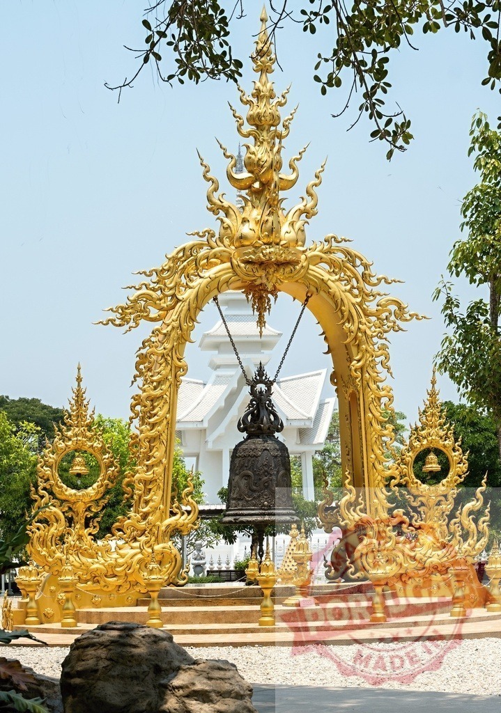 Ornate golden arch showcasing a large bell at Wat Rong Khun, Thailand | Golden arch with intricate details framing a large bell, a captivating scene at the renowned White Temple in Chiang Rai - Realisiert mit Pictrs.com