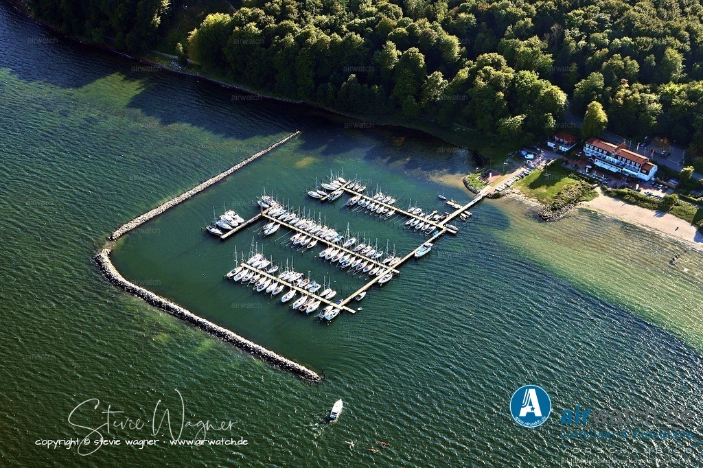 Luftbild Flensburger Foerde, Flensburg Wassersleben, Segel-Sport Flensburg Harrislee | Direkt angrenzend befindet sich das Clubhaus mit Küche, Gemeinschafts- und Sanitärräumen. Segeln im Verein wird als ideale Möglichkeit beschrieben, um Teamfähigkeit, Verantwortung und Naturverbundenheit zu fördern, besonders bei Kindern und Jugendlichen.