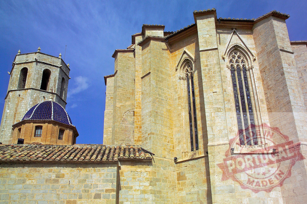 Tortosa Cathedral showcasing Gothic architecture and bell tower | Tortosa Cathedral bell tower and Gothic stone facade standing under a blue sky - Realisiert mit Pictrs.com