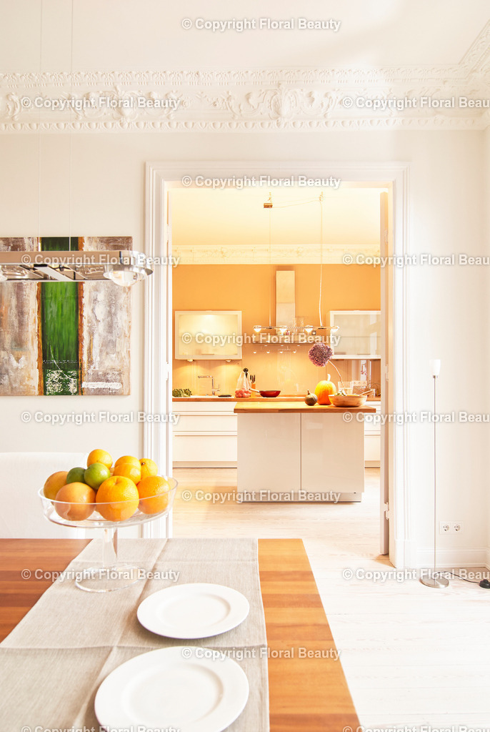 Esszimmer mit Blick in Küche | Blick vom Esszimmer in die modere Altbauküche mit Stuck. Kücheninsel. Beige Wandfarbe. - Realisiert mit Pictrs.com