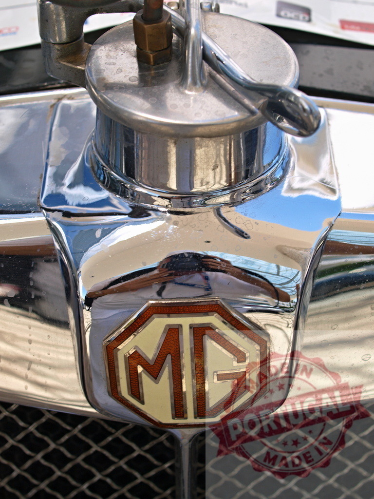Shiny Chrome MG Car Emblem Reflecting Light | Close-up of a polished MG car emblem with chrome detailing - Realized with Pictrs.com
