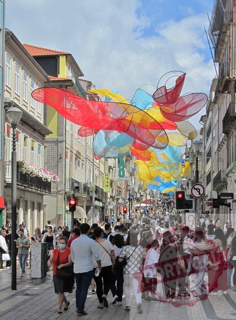 Porto city street art installation with crowds shopping. Porto - Portugal | Crowds of people walking along Rua de Santa Catarina under colorful art installation - Realized with Pictrs.com