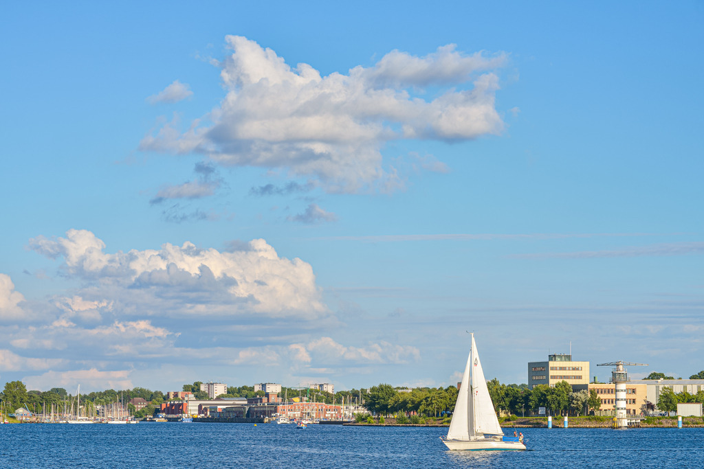 Segelboot Kieler Förde | Ein Segelboot in der Kieler Förde vor der Schwentine-Mündung. Das Sommerlicht und die Wolken erzeugen eine ruhige Abendstimmung. - Realisiert mit Pictrs.com