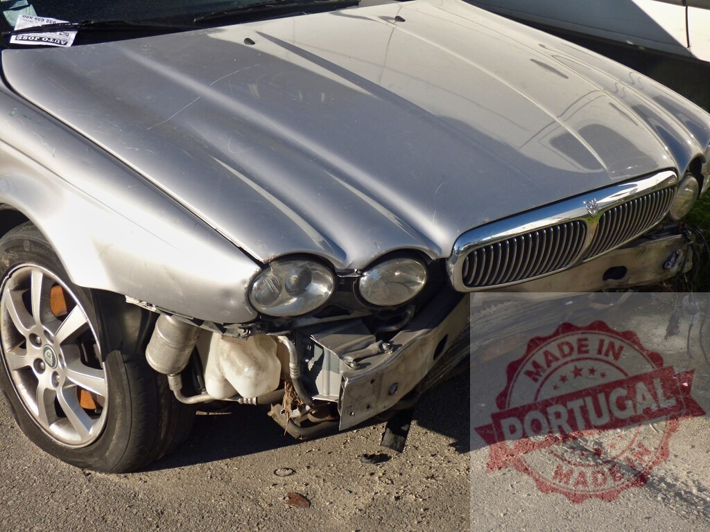 Silver Jaguar car showing severe frontal impact damage | Silver Jaguar car experiencing extensive front end collision damage after an accident - Realized with Pictrs.com