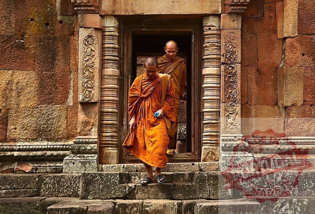 Two monks are descending stone stairs of an ancient temple | Buddhist monks descending ancient temple stairs in orange robes - Realized with Pictrs.com