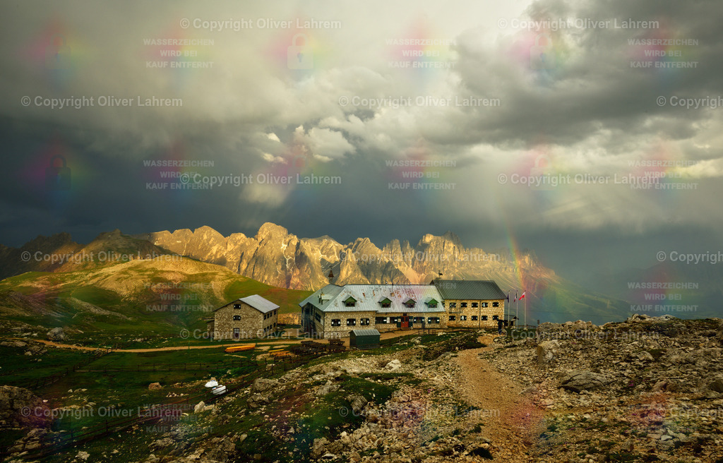 Der leuchtende Rosengraten | Eine dramatische Gewitterstimmung über dem Schlernhaus in den Dolomiten und der Rosengarten wird von Sonnenstrahlen angeleuchtet.