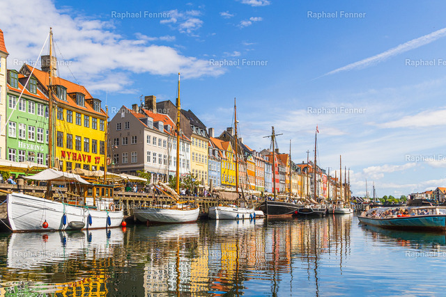 Nyhavn – Der historische Hafen von Kopenhagen | Dänemark | Nyhavn ist eines der bekanntesten Wahrzeichen Kopenhagens und ein Symbol für die maritime Geschichte Dänemarks. Die farbenfrohen historischen Häuser, traditionellen Segelschiffe und die ruhige Spiegelung im Wasser verleihen diesem Ort seinen unverwechselbaren Charakter. Dieses Bild entstand an einem sonnigen Sommertag und fängt die lebendige Atmosphäre des berühmten Hafens in einer harmonischen Komposition ein.Als hochwertiger Fine-Art-Druck bringt dieses Motiv die besondere Stimmung Kopenhagens in Wohnräume, Büros oder Ferienhäuser und eignet sich perfekt für Liebhaber skandinavischer Architektur und maritimer Landschaften.
