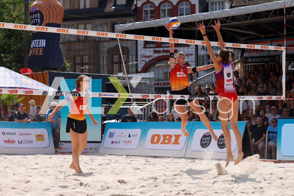 Obi BeachTour 2026 - Basel | BASEL, SWITZERLAND - JULY 19: LINDA ABBÜHL (SUI) attack / spike against NADINE DEMIERRE (SUI) block during the Obi BeachTour 2026 match between BOSSART / ABBÜHL (SUI) and FLÜCKIGER / DEMIERRE (SUI) at Barfüsserplatz on July 19, 2026 in Basel, Switzerland. - Realisiert mit Pictrs.com