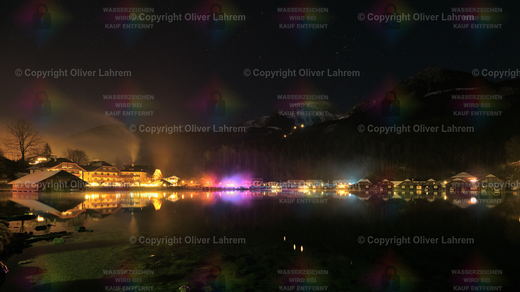 Neujahrsnacht am Königssee | Zum Neujahr ist die Seelände am Königssee bunt Beleuchtet und einzelne Laserstrahlen werden durch den leichten Nebel sichtbar. Der Himmel ist Sternenklar und die Häuser spiegeln sich im klaren Wasser des Königssee