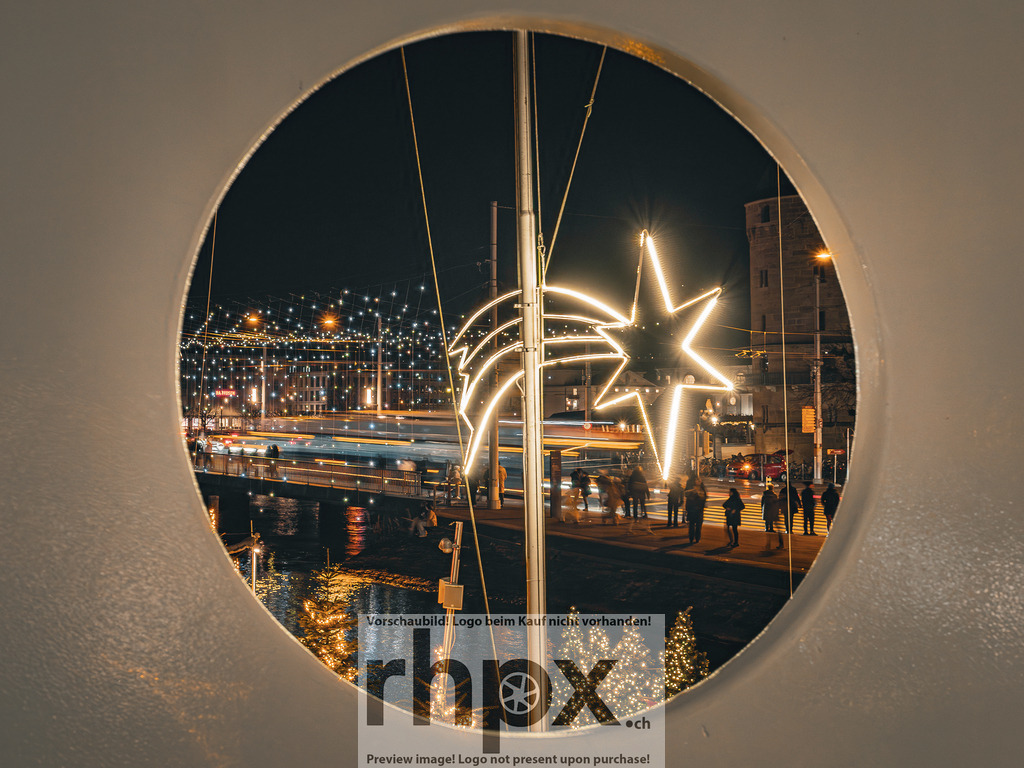 Advent am Schwanenplatz | Licht. Advent. Perspektive.Ein besonderer Blick durch das Bullauge eines Schiffes auf den festlich beleuchteten Schwanenplatz in Luzern. Die warme Weihnachtsbeleuchtung und das lebendige Treiben der Stadt verschmelzen zu einer stimmungsvollen Nachtaufnahme.Wähle unter "Produktauswahl" dein Wunschformat: Vom klassischen Wandbild über Puzzle &amp; Tassen bis zum digitalen Download (z.B. als Handy-Hintergrund). - Realisiert mit Pictrs.com