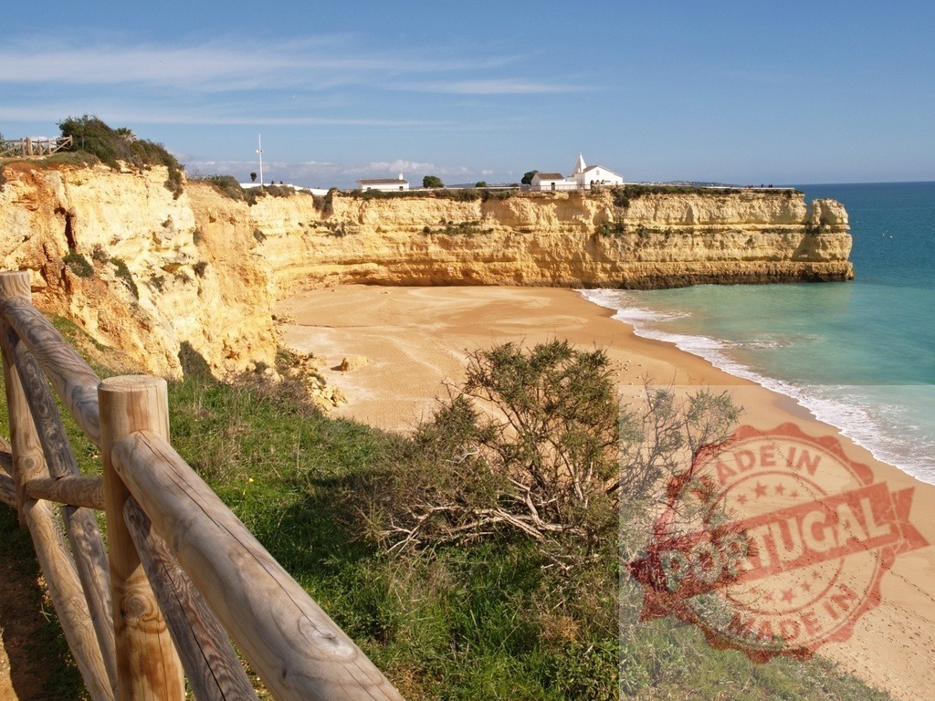 Algarve coast with sandy beach and orange cliffs | Sandy beach with turquoise ocean water, dramatic orange cliffs, and a small church on top - Realisiert mit Pictrs.com