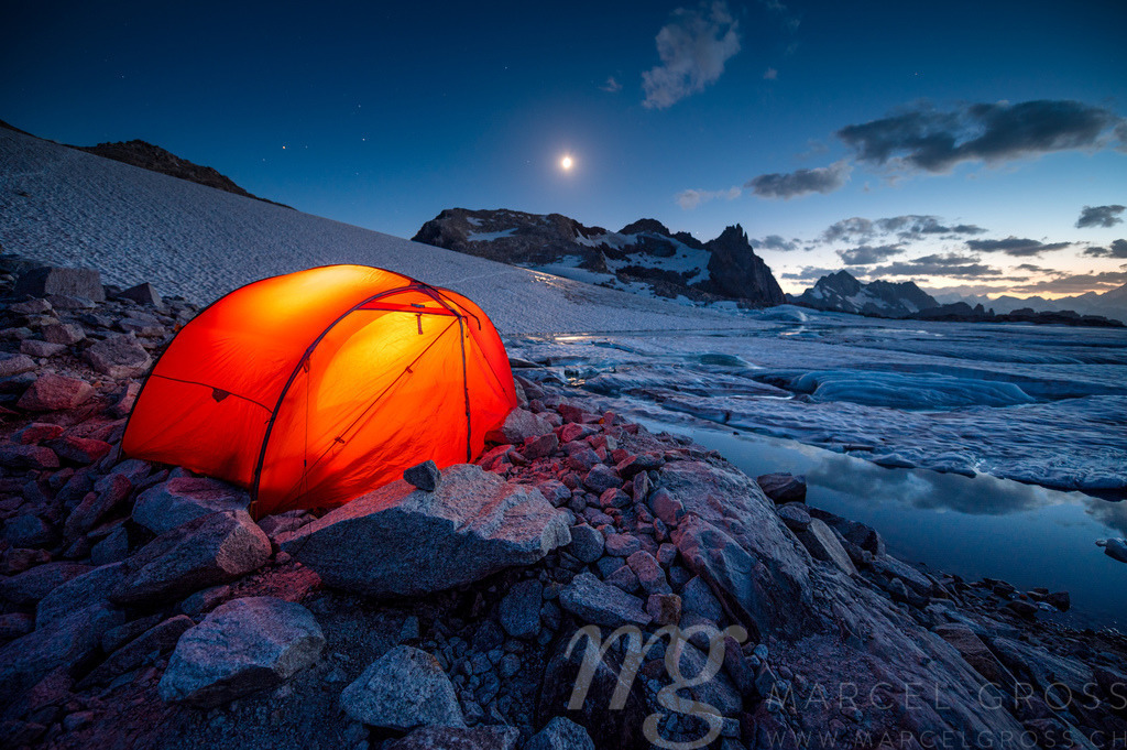 red tent camping at a glacier lake in the swiss alps | Die ideale Geschenkidee für Naturliebhaber. Naturbilder von Marcel Gross Photography für ihr Zuhause in den verschiedensten Formaten und Materialien. - Realisiert mit Pictrs.com