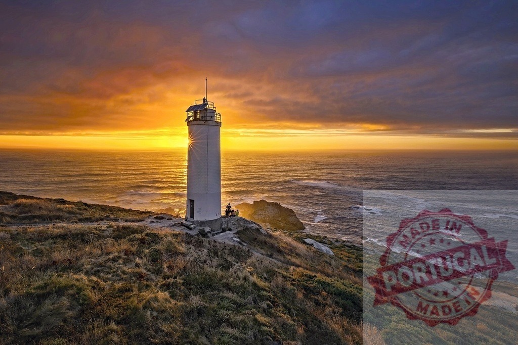 Lighthouse standing on cliff watching sunset over ocean. Galicia - Spain | Lighthouse standing on a grassy cliff with ocean waves breaking and a dramatic sunset sky providing light - Realized with Pictrs.com