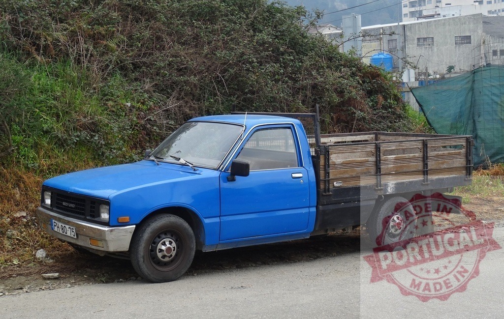Blue Bedford Isuzu Faster pickup truck parked rural road | Blue Bedford Isuzu Faster pickup truck with a wooden flatbed parked on a rural road - Realisiert mit Pictrs.com