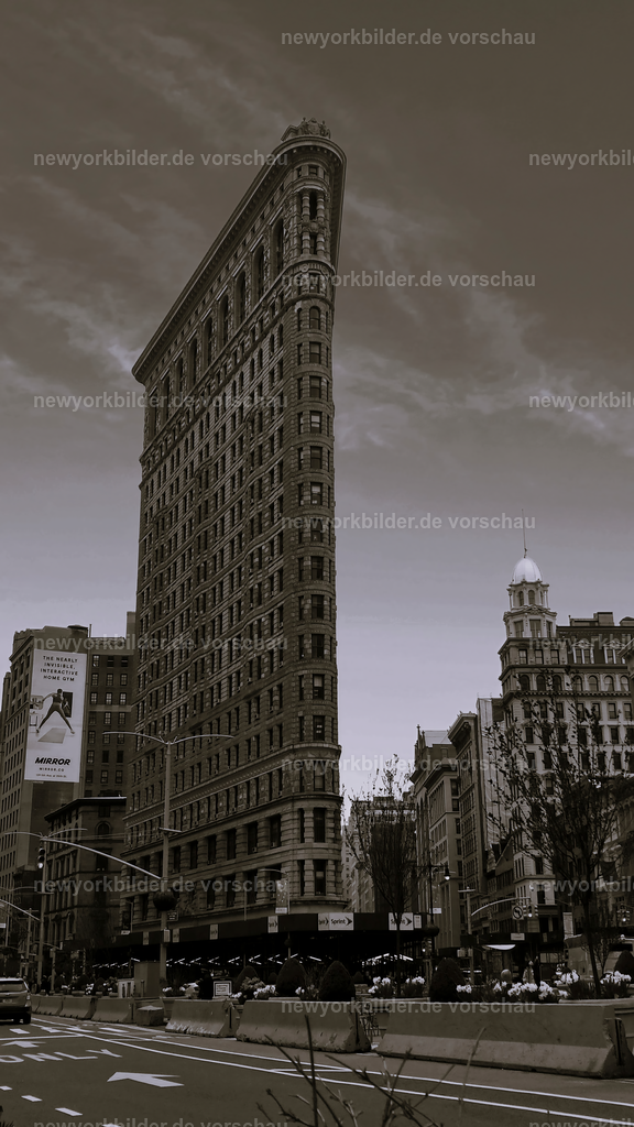 Flatiron Building in Schwarz-Weiß – Ein ikonisches Wahrzeichen von New York | Das Flatiron Building ist eines der bekanntesten Wahrzeichen New Yorks – und in Schwarz-Weiß wirkt es noch eindrucksvoller. Am Fuße des Gebäudes offenbart sich seine einzigartige Form, die seit über einem Jahrhundert die Fantasie von Fotografen und Architekturliebhabern beflügelt. Die monochrome Darstellung betont die klaren Linien, die kunstvollen Details und die zeitlose Eleganz dieses Meisterwerks. Inmitten des pulsierenden Stadtlebens entsteht ein Bild, das Geschichte und Moderne vereint. Für alle, die New York lieben, ist das Flatiron Building ein Muss – ein Ort, der die Seele der Metropole einfängt und in jeder Perspektive fasziniert.