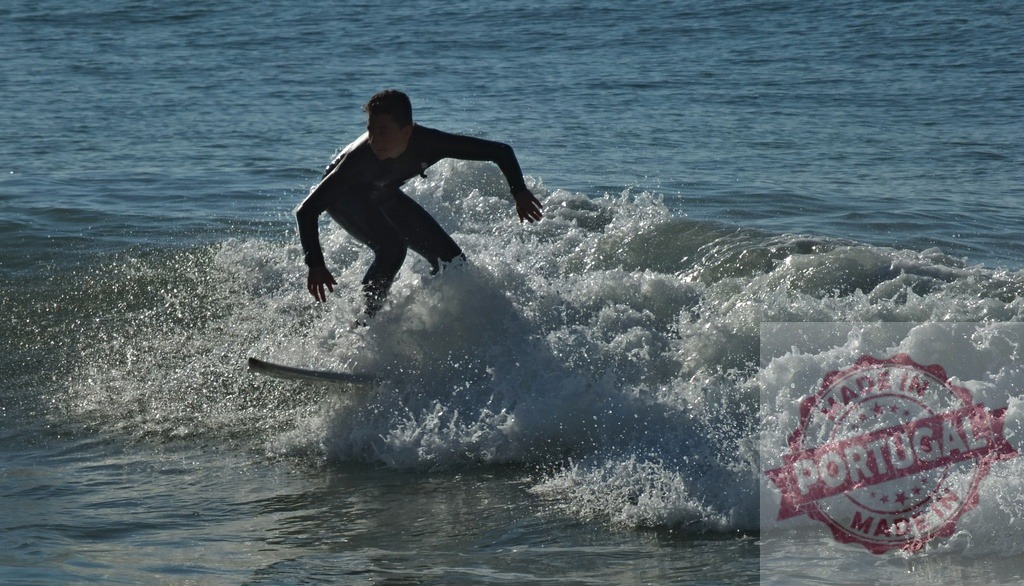 Surfer riding ocean wave with splashing water | Surfer in wetsuit riding a breaking ocean wave, splashing water around board - Realisiert mit Pictrs.com