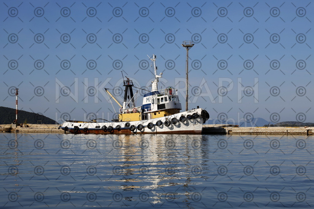 Hafenschlepper Thiella | Der Hafenschlepper Thiella am Hafen von Igoumenitsa. Im Hintergrund erhebt sich die nordgriechische Bergkulisse in den blauen Himmel über dem Mittelmeer.