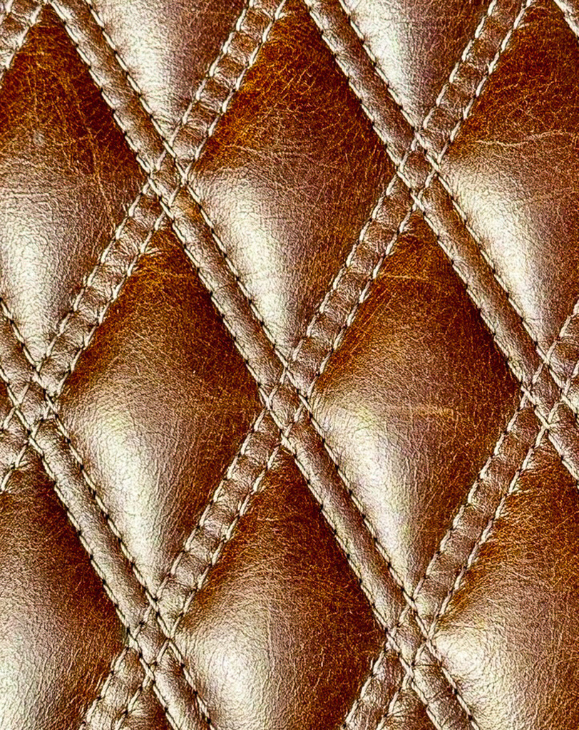 Edles Leder Rautenmuster | Minimalist Luxury Texture | Elegante Makroaufnahme von gestepptem Leder im Rauten-Design. Das feine Zusammenspiel von Licht und Schatten auf der strukturierten Oberfläche erzeugt ein minimalistisches, luxuriöses Muster. Perfekt als moderne Wandkunst, exklusives Poster oder als Textur-Hintergrund für Designer. / Luxury stitched leather texture. - Realisiert mit Pictrs.com