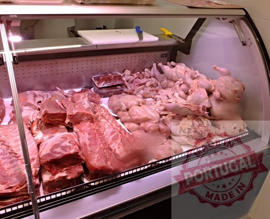Raw meat and fresh poultry in butcher shop display | Various raw meat cuts and whole chickens displayed in a refrigerated case - Realized with Pictrs.com