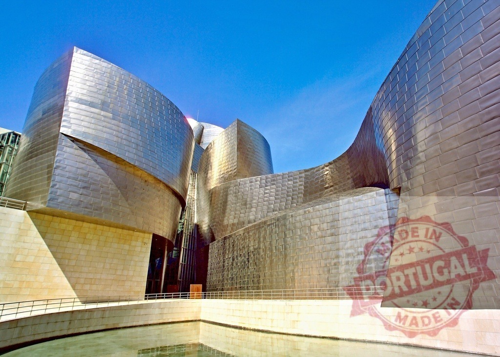Guggenheim Museum Bilbao with titanium curves reflecting blue sky. Spain - Bilbao | Guggenheim Museum Bilbao featuring deconstructivist architecture, titanium panels, and water reflection - Realisiert mit Pictrs.com