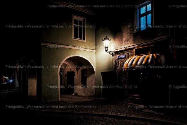 Nachtstimmung in der Altstadt | Ruhige Nachtaufnahme einer alten Gasse mit beleuchteter Laterne, Torbogen und blauem Fensterlicht. Die dunkle Umgebung, das warme Licht und die historische Architektur erzeugen eine geheimnisvolle, filmische Atmosphäre. - Realisiert mit Pictrs.com