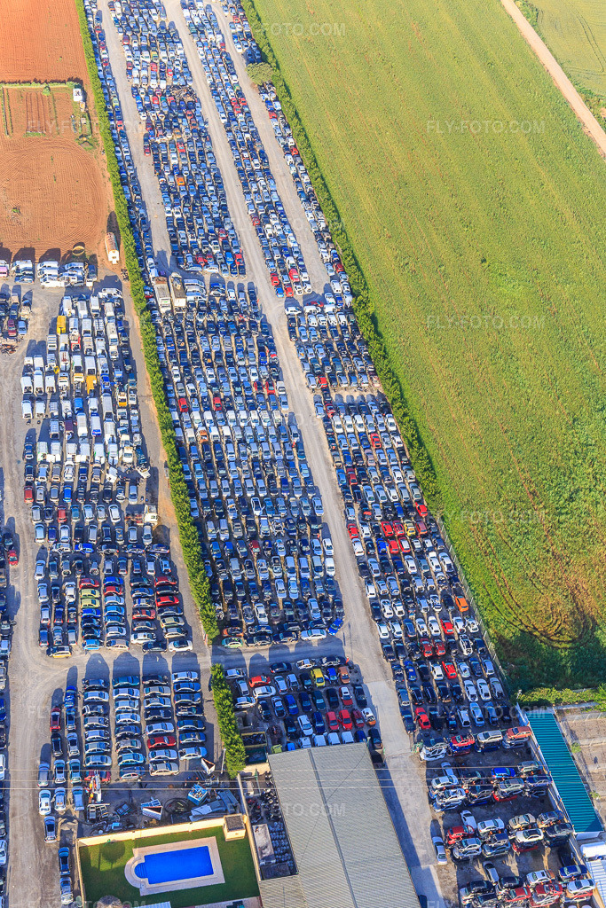 Aerial view: Rows of stacked old vehicles at the Desguace Siglo 21 scrapyard in Dos Hermanas in the state Seville, Spain.Photo: IMG_145747.jpg taken on 04/22/2025 by Werner Riehm/FLY-FOTO.comResolution of the original: 3648 x 5472 pxWWW.DESGUACESIGLOXXI.COM
