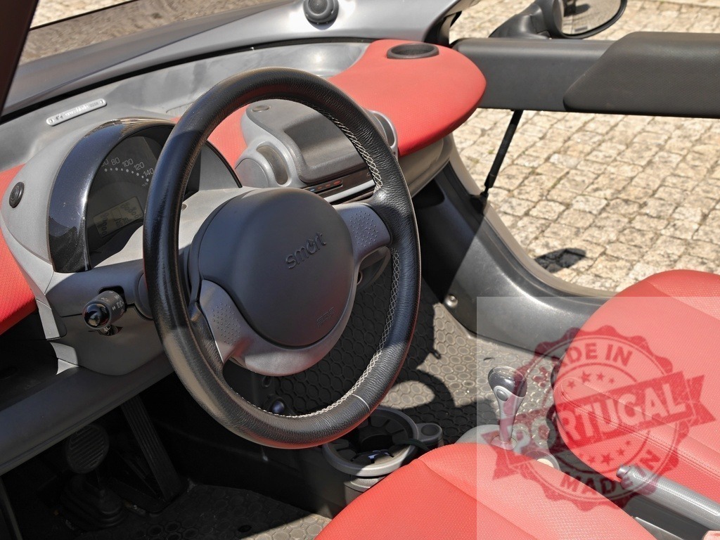 Smart car interior with red seats and steering wheel | Smart car interior featuring a dashboard, steering wheel, gear shift, and red leather seats - Realized with Pictrs.com