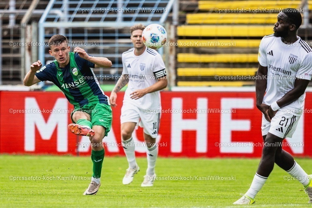 xKWI02082501043 | 02.08.2025, xkwix, Fußball, Regionalliga West, FC Gütersloh - 1. FC Bocholt, Ohlendorf Stadion im Heidewald: Aleksandar Kandic ( FC Gütersloh #27 ) beim Schuss und Jeff Mensah (1.FC Bocholt #21) im Block