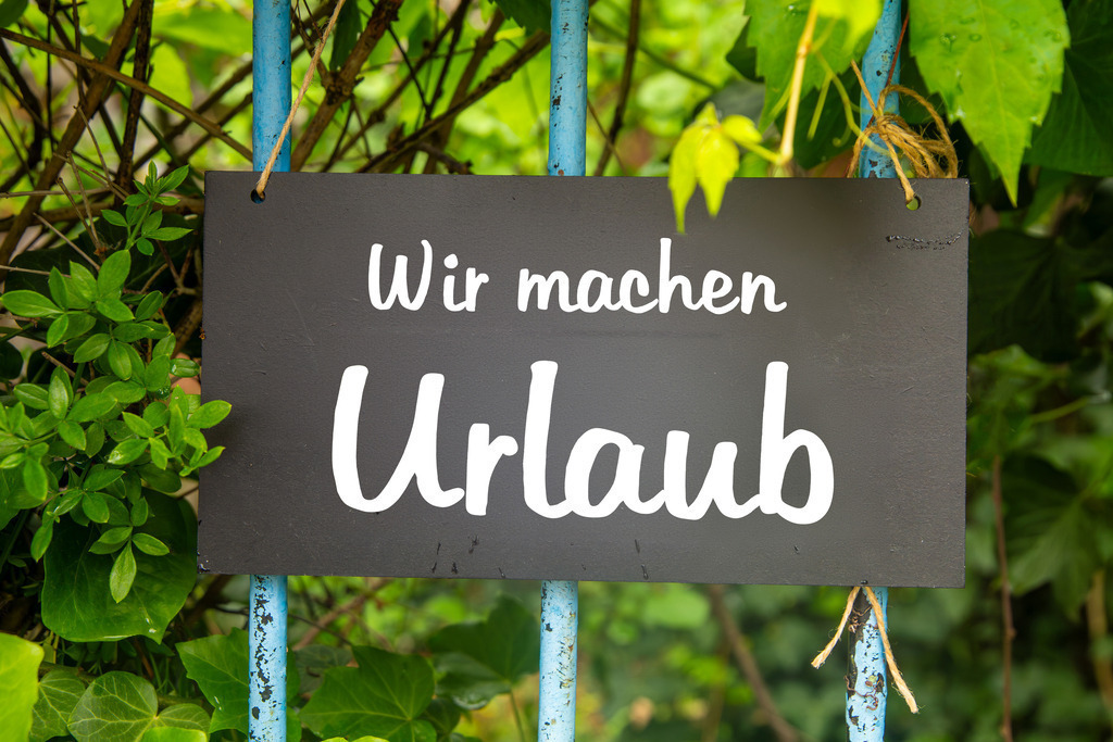 Symbolbild Betriebsferien/Urlaub: Schild am Garten mit der Aufschrift WIR MACHEN URLAUB | Symbolbild Betriebsferien/Urlaub: Schild am Garten mit der Aufschrift WIR MACHEN URLAUB - Realisiert mit Pictrs.com