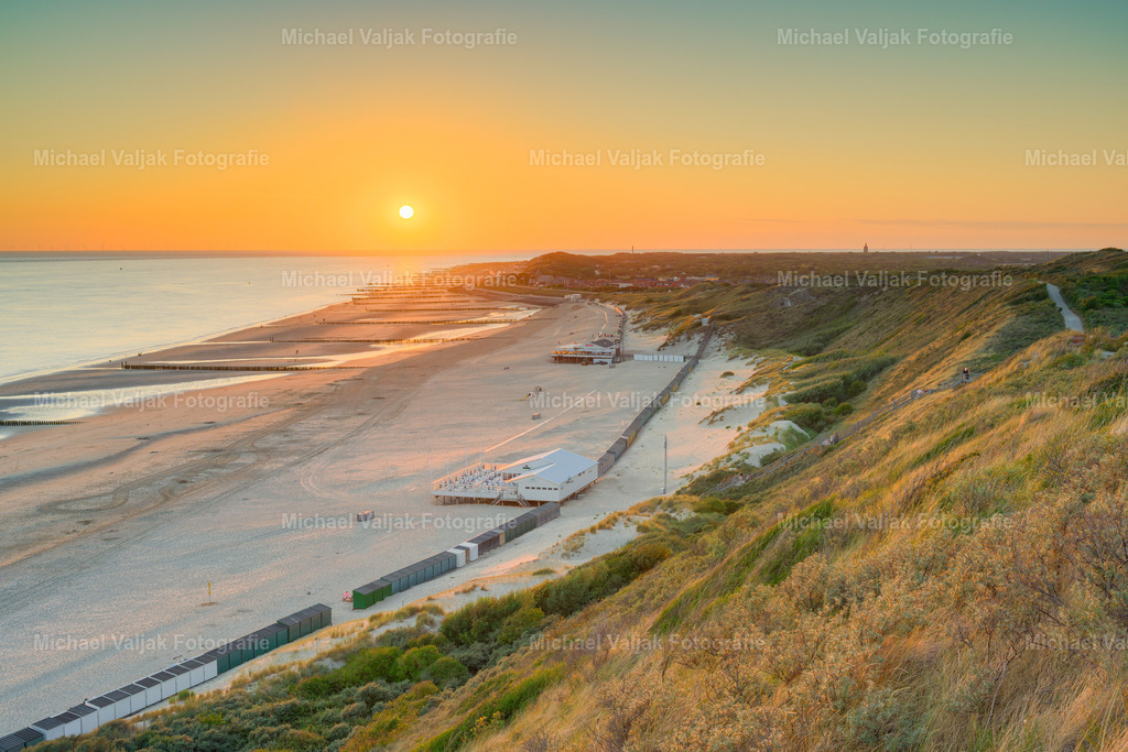 Abendstimmung über Zoutelande | Die letzten Sonnenstrahlen des Tages tauchen den Strand von Zoutelande in ein warmes, goldenes Licht. Von den Dünen aus reicht der Blick weit über den breiten Sandstrand und die Nordsee, während sich die Küste sanft bis zum Horizont erstreckt.Das warme Licht des Sonnenuntergangs setzt einen eindrucksvollen Kontrast zu den natürlichen Farben von Dünen, Strand und Meer. Die weite Landschaft und der offene Horizont vermitteln Ruhe, Freiheit und das besondere Gefühl eines Sommerabends an der niederländischen Küste.Ein atmosphärisches Landschaftsfoto von Zoutelande in Zeeland, das die stille Schönheit und charakteristische Weite der Nordseeküste in den Abendstunden einfängt. - Realisiert mit Pictrs.com