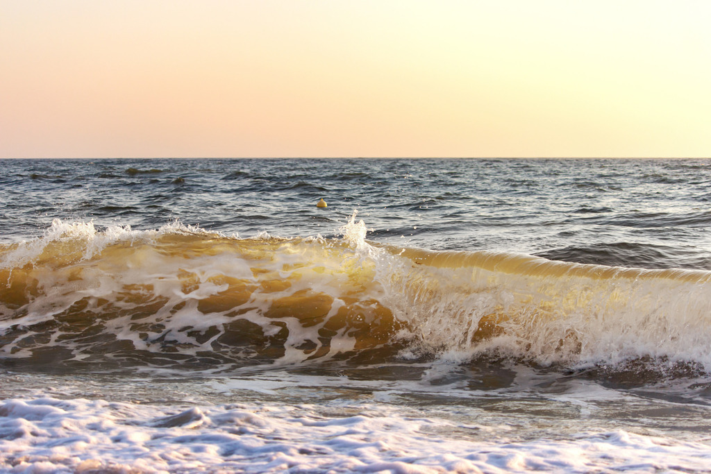 Wandbild: Welle im Morgenrot an der Ostsee | Dieses maritime Wandbild im Querformat zeigt eine Sonnendurchflutete Welle im Morgenrot. Der Himmel ist komplett in ein pastellartiges rotorange getaucht welches auf Ihren Wänden für eine wohnliche Stimmung sorgt. Diese Farben leuchten auch durch die brechende Welle. Das Meer zwischen Himmel und Welle wirkt eher ruhig und bringt ein edles graublau aufs Wandbild. Holen Sie sich diese schöne maritime Morgenstimmung auf Leinwand, Aluminium-Platte oder Acrylglas. Ideal fürs Wohnzimmer, Schlafzimmer, Küche, den Arbeitsplatz oder die Ferienwohnung.   - Realisiert mit Pictrs.com