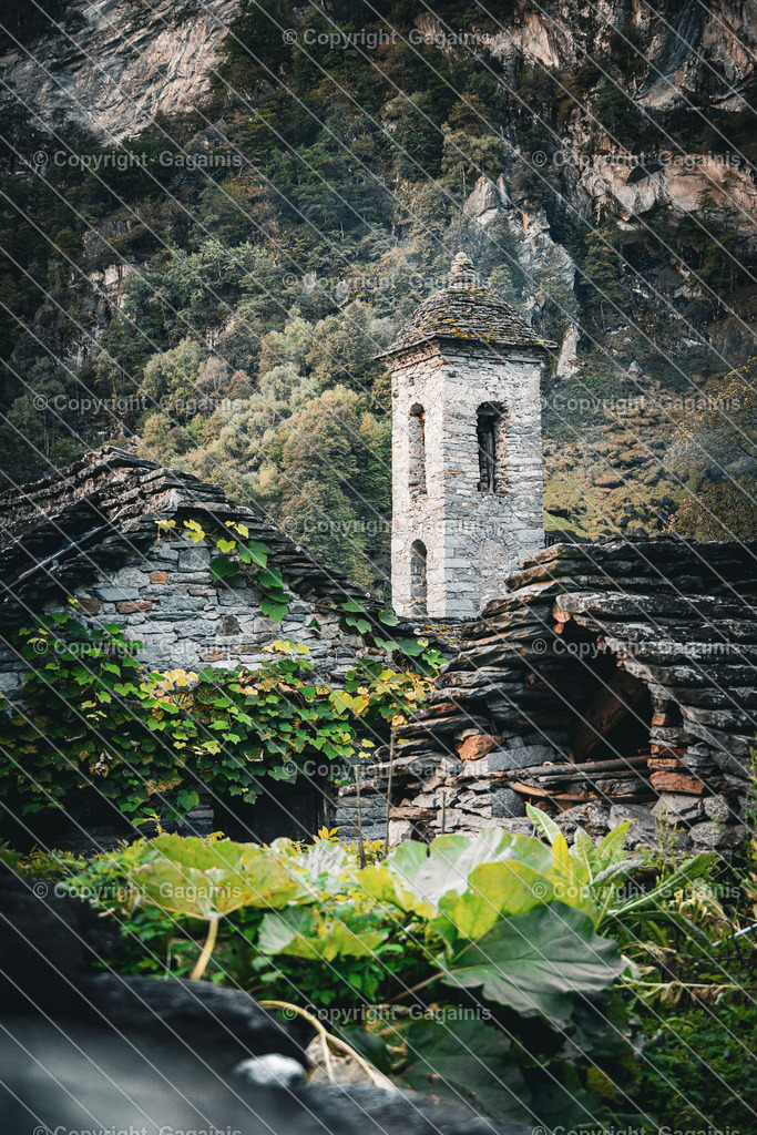 Foroglio Kirchenturm | Foroglio ist ein malerisches Bergdorf im Bavonatal im Tessin, Schweiz. Es ist bekannt für seinen beeindruckenden Wasserfall, der rund 80 Meter tief in das Tal stürzt, sowie für seine traditionellen Steinhäuser, engen Gassen und unberührte alpine Landschaft. Das Dorf wirkt wie aus einer anderen Zeit und zieht Natur- und Fotoliebhaber gleichermaßen an.