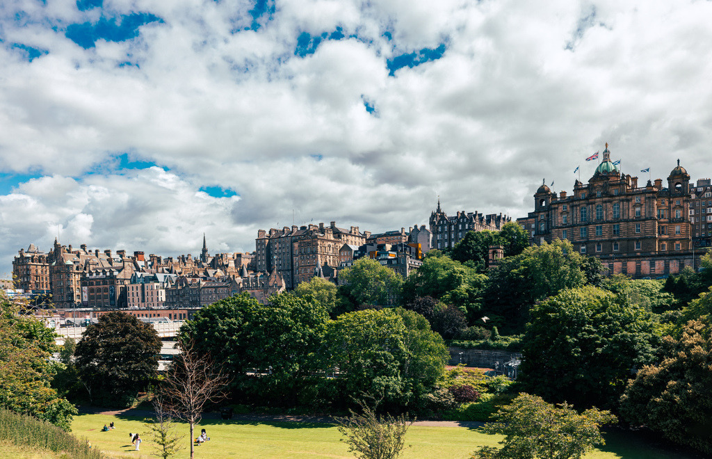 Altstadt von Edinburgh und das Edinburgh Castle----Skyline | Dieses Bild zeigt den Blick über die Princes Street Gardens auf die Altstadt von Edinburgh.Im Vordergrund befindet sich der weitläufige Park mit grünem Rasen und Bäumen.Im Hintergrund ist die historische Skyline der Stadt mit traditioneller Architektur aus Sandstein zu sehen.Das Wahrzeichen Edinburgh Castle ist auf dem Hügel im Hintergrund erkennbar - Realisiert mit Pictrs.com