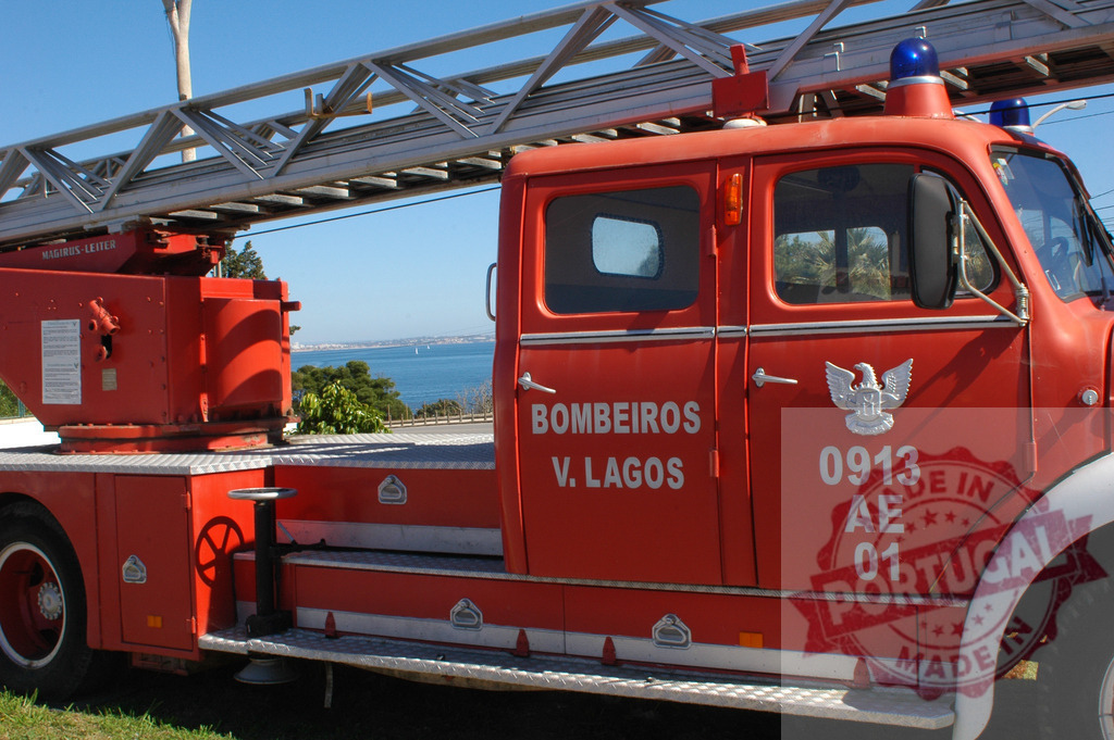 Portuguese fire truck with ladder against scenic ocean view | Red fire truck from Bombeiros Voluntários de Lagos parked overlooking the Atlantic Ocean - Realisiert mit Pictrs.com