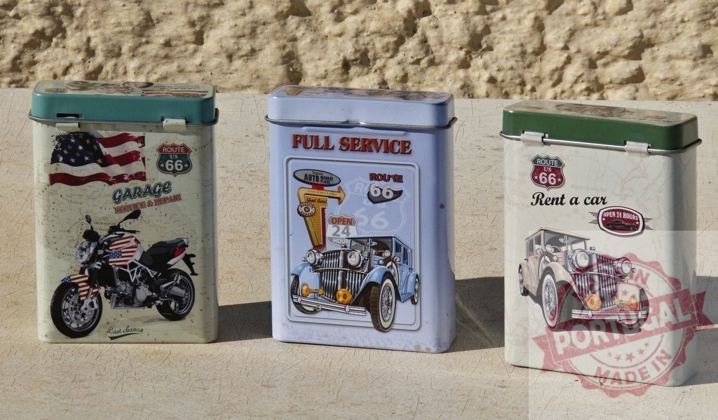 Route 66 Americana advertising design on vintage tins | Decorative metal boxes depicting classic cars, motorcycles, and Route 66 signs on a light background - Realisiert mit Pictrs.com