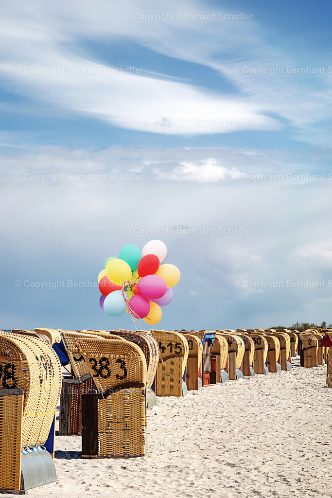 Strandkörbe und Luftballons | Viele Strandkörbe an einem Sandstrand der Ostsee in der Kieler Förde mit Wolken und bunten Luftballons.  - Realisiert mit Pictrs.com