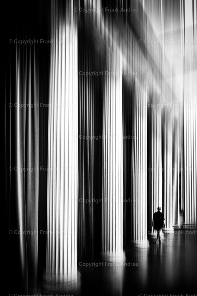 Potsdam | Eine Frau in der Kirche St. Nikolai in Potsdam. Sie geht entlang der Säulen. Die Vorhänge hinter den Säulen verleihen dem Moment eine besondere Atmosphäre. Fine art Straßenfotografie in schwarz und weiß. - Realisiert mit Pictrs.com