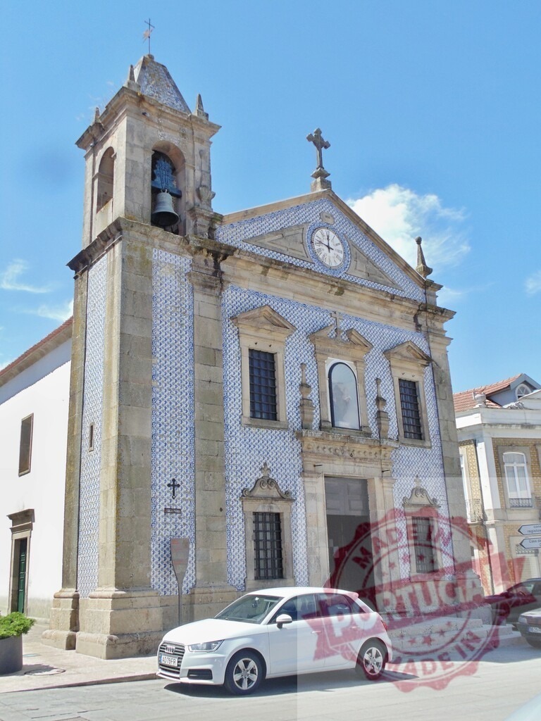 Portuguese church facade with blue azulejos and bell tower. Aveiro - Portugal | Historic church in Portugal featuring a traditional facade with blue and white azulejo tiles - Realized with Pictrs.com