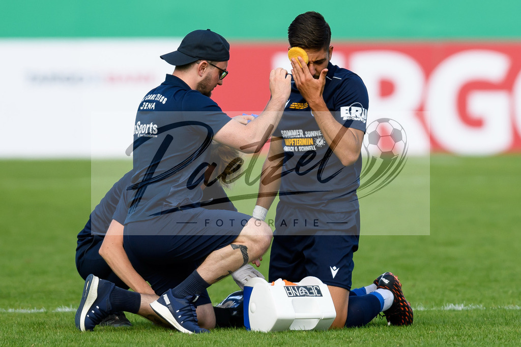 JENKOE20210808_304 | Fussball, Herren: Justin Schau (FC Carl Zeiss Jena) wird behandelt beim Spiel der 1. Runde im DFB-Pokal zwischen FC Carl Zeiss Jena und 1. FC Koeln im Ernst-Abbe-Sportfeld am 08.08.2021 in Jena, Deutschland.DFB / DFL REGULATIONS PROHIBIT ANY USE OF PHOTOGRAPHS AS IMAGE SEQUENCES AND/OR QUASI-VIDEO. - Realisiert mit Pictrs.com