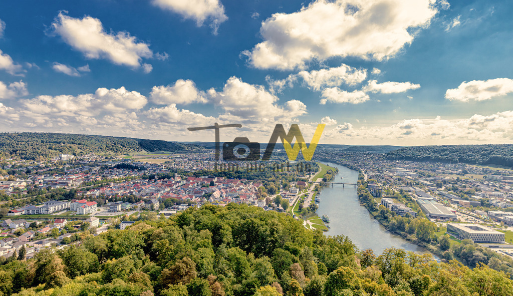 Panoramablick über die Stadt Kehlheim und der Donau/Altmühl | Das Bild zeigt eine Luftaufnahme der Stadt Kelheim in Niederbayern. Kelheim ist die Kreisstadt des gleichnamigen Landkreises und liegt im Herzen Bayerns, eingebettet in eine eindrucksvolle Naturlandschaft. Die Stadt liegt am Zusammenfluss von Donau und Altmühl. Die Befreiungshalle, ein imposanter Rundbau, überragt die Stadt auf einem Bergsporn zwischen Donau- und Altmühltal. Die Region um Kelheim ist für das Donautal und den Donaudurchbruch bekannt, die 1840 zum ersten Naturschutzgebiet Bayerns erklärt wurden.  - Realisiert mit Pictrs.com