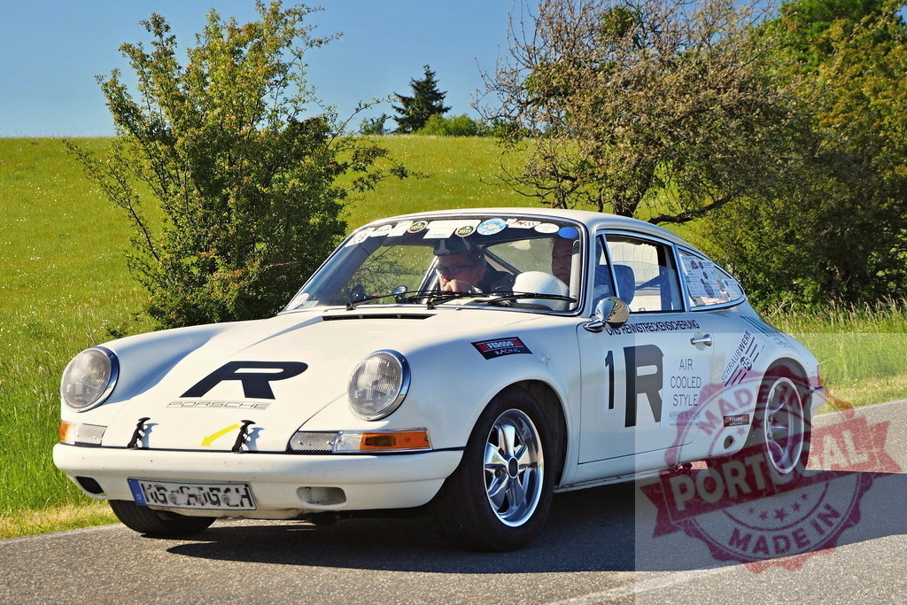 White Porsche 911 classic rally car driving | Vintage Porsche 911 participating in a historic car rally on a country road - Realized with Pictrs.com