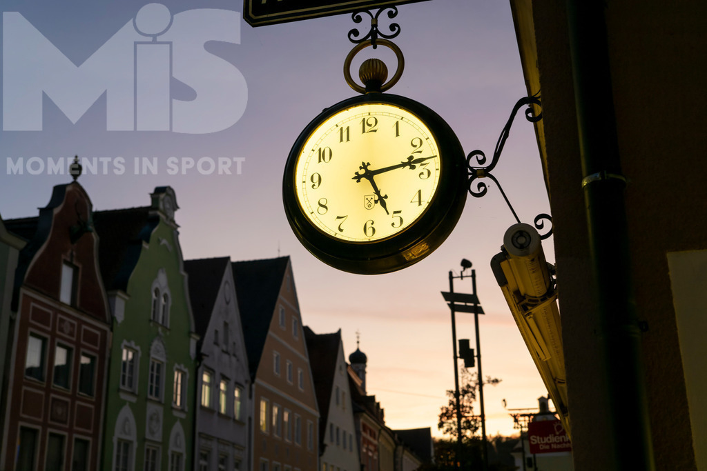 MIS_170320cm035.JPG | 11.11.2022, Mindelheim (Unterallgäu) Stadtansicht, Abenddämmerung in der historischen Altstadt, die Hänge-Uhr an der Fassade eines Uhrengeschäfts zeigt die Zeit an. - Realisiert mit Pictrs.com