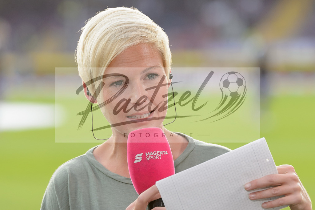 OSNVKO2021090620210906_257 | Fussball, Herren: MagetaSport-Moderatorin Anett Sattler schaut beim Spiel der 3. Liga zwischen VfL Osnabrueck und FC Viktoria Koeln im Stadion an der Bremer Bruecke am 06.09.2021 in Osnabrueck, Deutschland.DFB / DFL REGULATIONS PROHIBIT ANY USE OF PHOTOGRAPHS AS IMAGE SEQUENCES AND/OR QUASI-VIDEO. - Realisiert mit Pictrs.com