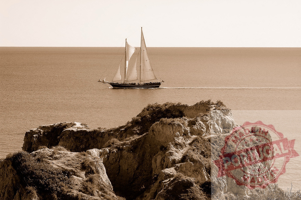 Vintage sailboat sailing past coastal cliffs, sepia tone | Schooner sailing on a calm ocean with cliffs in the foreground creating a serene maritime scene - Realized with Pictrs.com